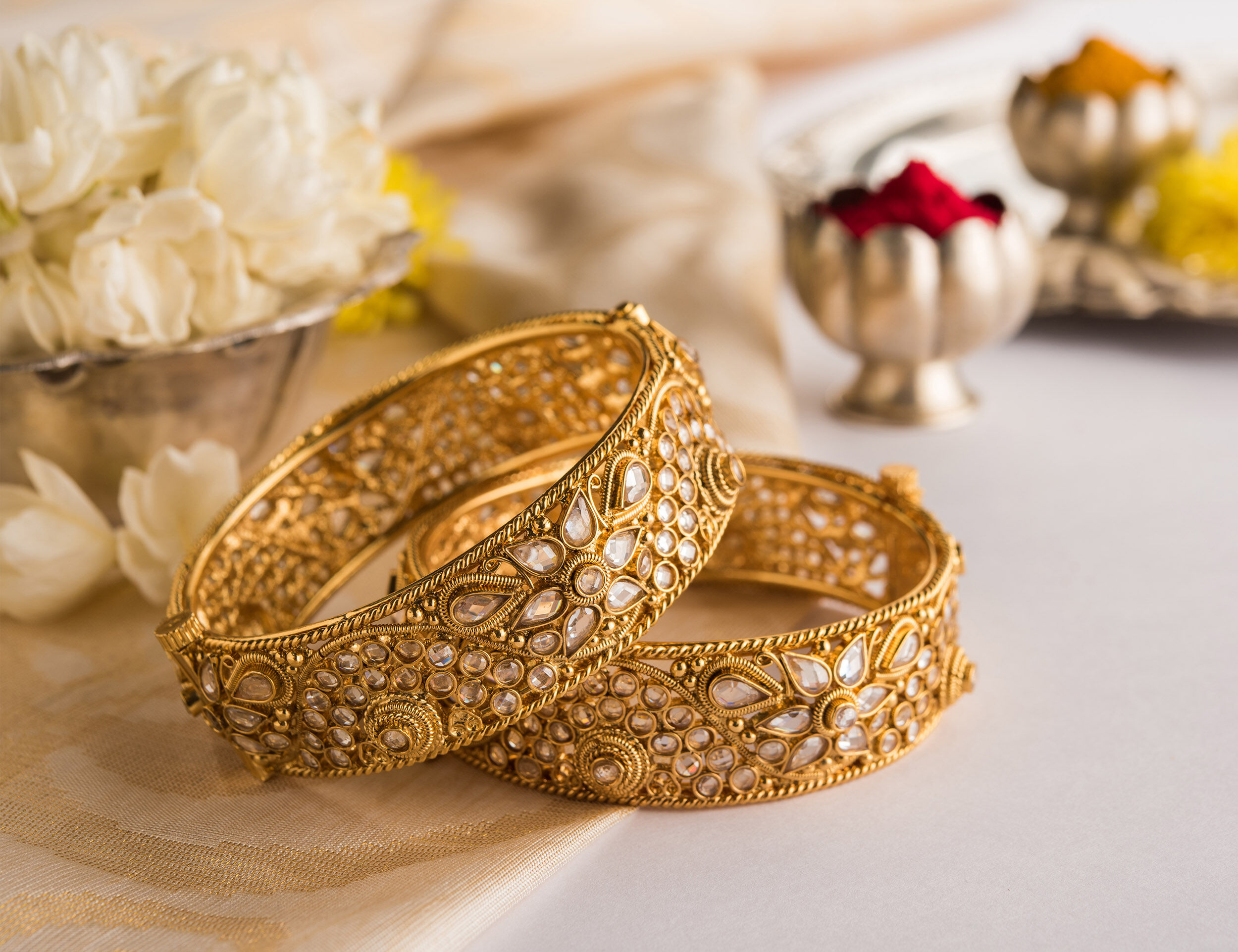 A pair of beautifull gold bangles with sindoor in bowl in bacground for bride 